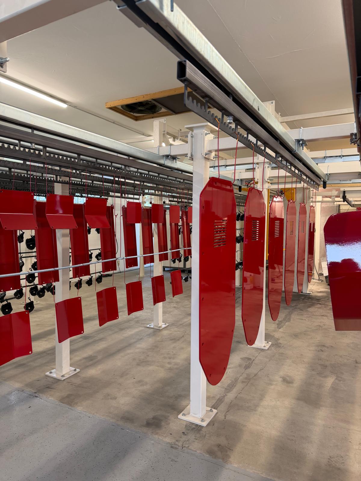 Rot pulverbeschichtete Bauteile an der Förderanlage – ProPulver Werkstatt